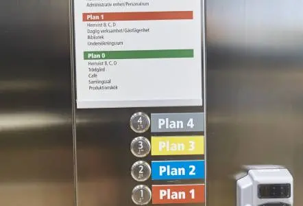 Knappanelen i en hiss där varje plan har en egen färg.