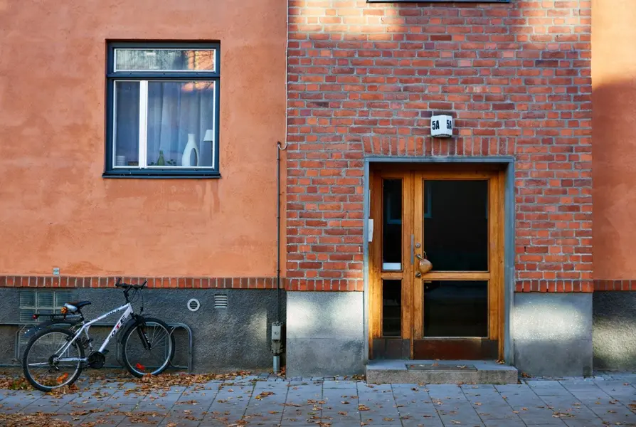 Enkel träport till flerbostadshus med röd tegelfasad på Domkyrkoesplanaden. Foto: Lasse Fredriksson