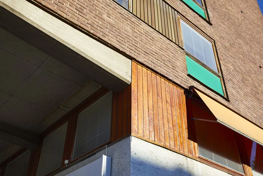 Detalj på fasaden där den rödbruna tegelfasaden möter fönsterpartier av trä, koppar och lättmetall. Foto: Lasse Fredriksson