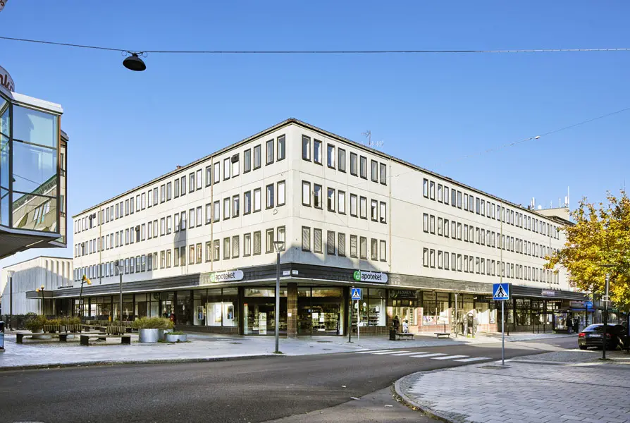 Vy från korsningen Stora gatan och Källgatan mot gamla Tingshusets fyravåningshus med ljus fasad och fönster på rad. Foto: Lasse Fredriksson
