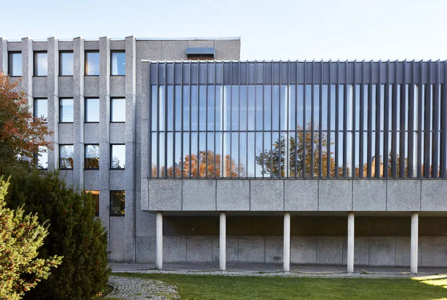 Vy från Västra Ringvägen som visar två av de olika byggnadskropparna. En med betongelement och rader av fönster i fasaden och den andra på pelare och med stora glasytor i fasaden. Foto: Lasse Fredriksson