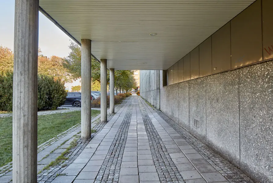 En arkad med smäckra runda betongpelare som håller upp en av de osymmetriskt placerade delarna av byggnaden. Foto: Lasse Fredriksson