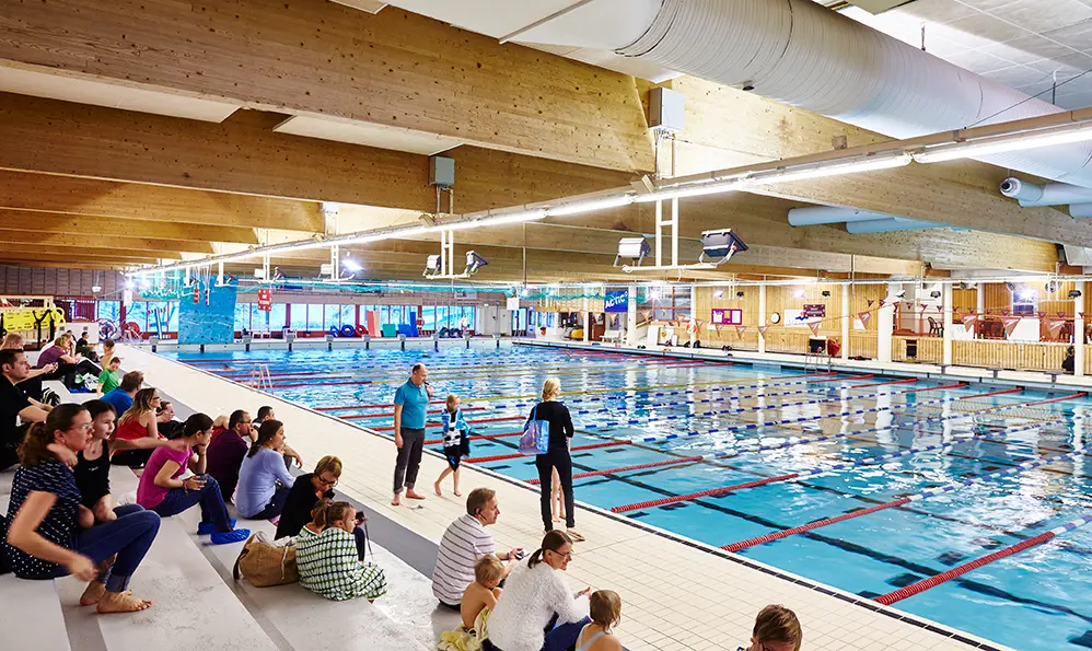 Bassäng i Lögarängsbadet, åskådare tittar på simträning.