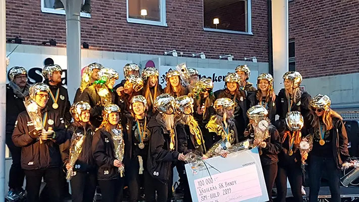 VSK Bandys damlag tog SM-guld 2019 vilket firades på Sigmatorget. Laget står på scenen, iklädda guldhjälmar och medaljer.