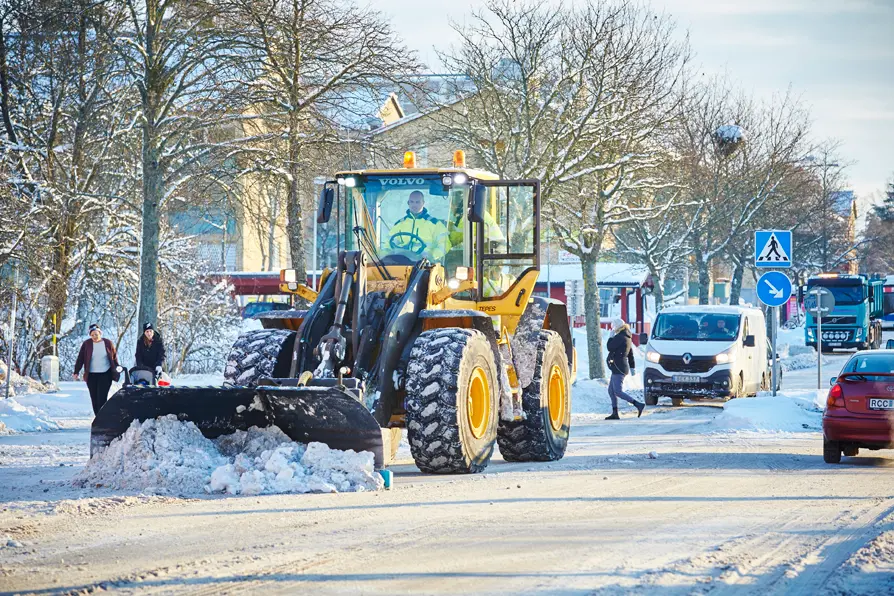 Traktor som plogar snö i stadsmiljö