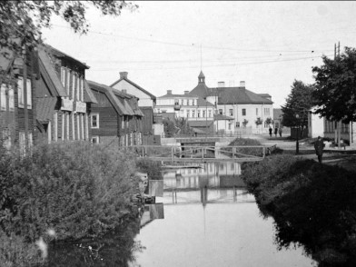 Svartvit bild av Lillån öster ut, med Västerås byggnader på båda sidor av ån.