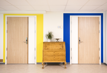 Två dörrar där en har gult och en har blått målat runt karmen. 