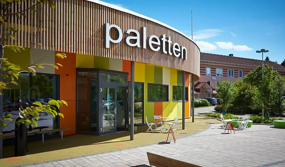 Bild på utsidan av Paletten som är ett aktivitetshus på Vallby. Fotot är taget en solig vårdag.