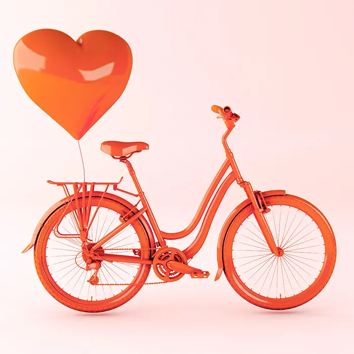 Bild på cykel med en ballong som svävar ovanför pakethållaren. Ballongen är hjärtformad.