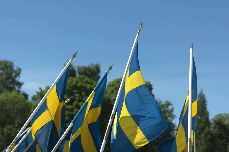 Flera svenska flaggor mot blå himmel. 