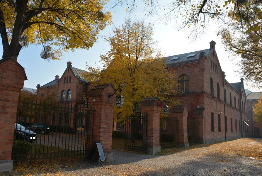 Byggnader i rött tegel med tegel- och smidesstaket på Kopparlunden. Foto: Emma Karp Västmanlands läns museum.