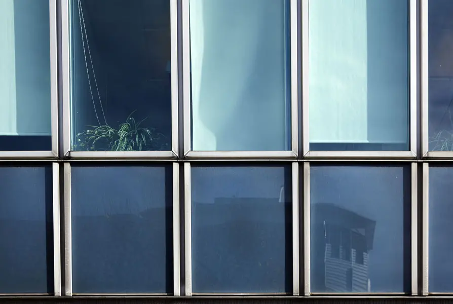 Detaljvy på västra glasfasaden som omväxlande består av omväxlande fönster och blå glasskivor. Foto: Lasse Fredriksson